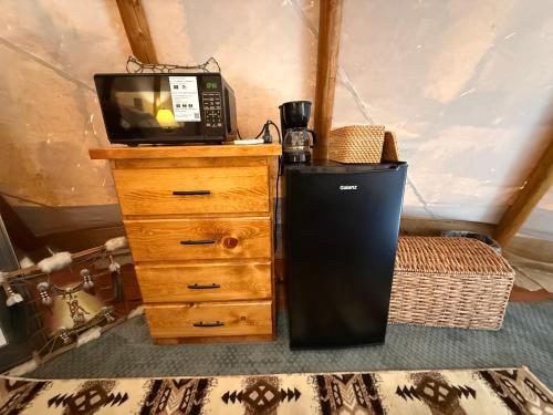 a room with a television and a dresser with a microwave at North Haven Campground in Bonners Ferry
