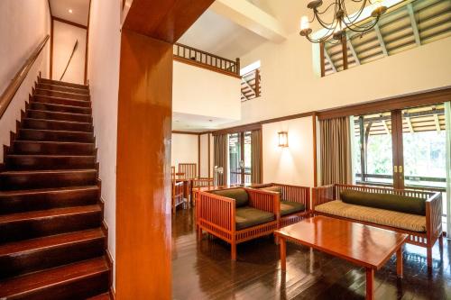 a lobby with couches and a table and stairs at Novotel Bogor Golf Resort in Bogor