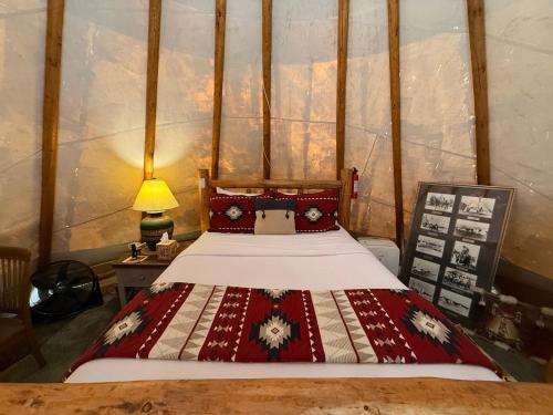 a bedroom with a bed and a table with a lamp at North Haven Campground in Bonners Ferry