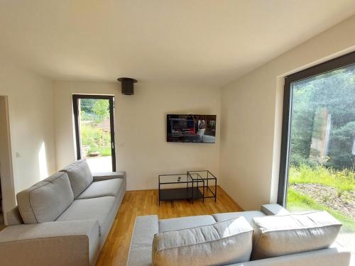 a living room with a couch and a large window at Chalet Víchová se saunou in Víchová nad Jizerou