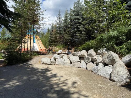 a pile of rocks next to a group of trees at North Haven Campground in Bonners Ferry