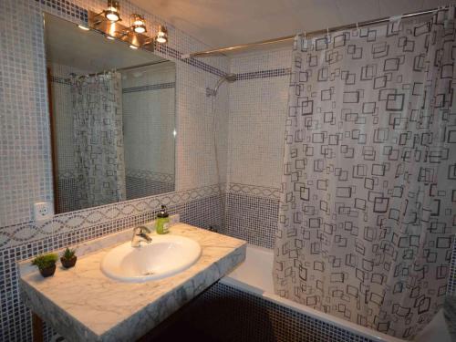 ein Badezimmer mit Waschbecken und Dusche mit Spiegel in der Unterkunft Apto. céntrico en Sant Pere Pescador - Piscina, jardín, A/C, terraza grande, wifi - ES-89-88 in Sant Pere Pescador