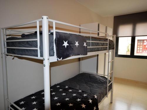 1 Schlafzimmer mit 2 Etagenbetten mit amerikanischer Flagge in der Unterkunft Apto. céntrico en Sant Pere Pescador - Piscina, jardín, A/C, terraza grande, wifi - ES-89-88 in Sant Pere Pescador