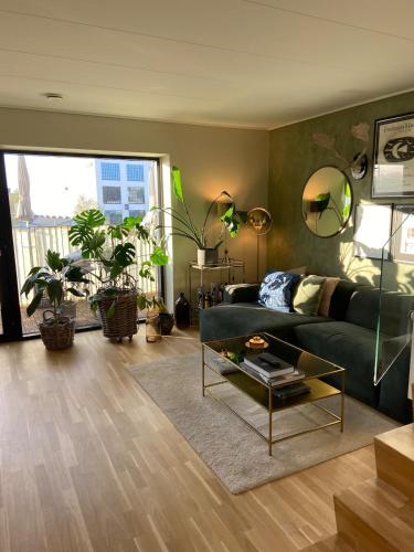 a living room with a green couch and a table at Contemporary and Luxurious in Copenhagen
