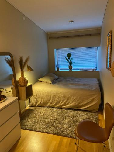a bedroom with a bed and a window and a chair at Contemporary and Luxurious in Copenhagen
