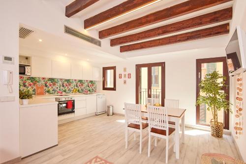 una cucina con armadi bianchi, tavolo e sedie di Remolars3 Townhouse - Turismo de Interior a Palma de Mallorca
