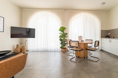 a large living room with a table and chairs at UG Boutique - סוויטות מדהימות ומעוצבות מול הכנרת in Tiberias