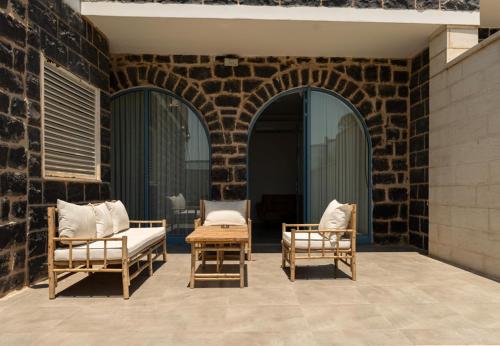 a patio with two chairs and a table at UG Boutique - סוויטות מדהימות ומעוצבות מול הכנרת in Tiberias