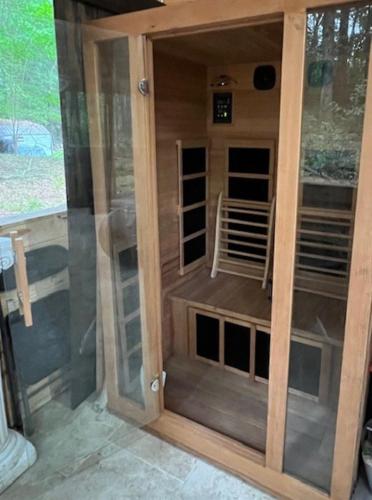 a sauna with a glass door in a house at Priv Hidden retreat ATV trails spa fishing outdoor activities in Jefferson