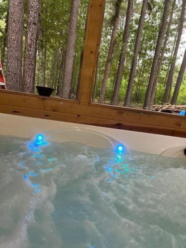 a hot tub with blue lights in front of a window at Priv Hidden retreat ATV trails spa fishing outdoor activities in Jefferson
