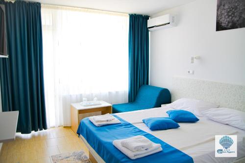 a bedroom with a bed and a blue chair at Hotel Carmen Azzuro in Venus