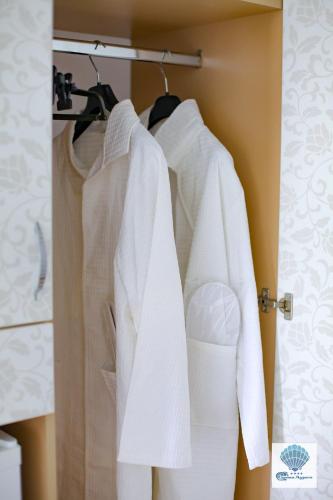 a group of white towels hanging on a rack in a bathroom at Hotel Carmen Azzuro in Venus