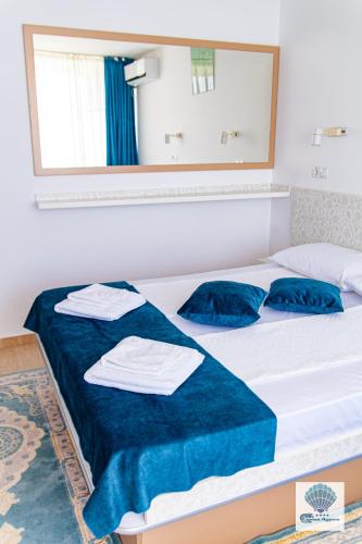 a bedroom with a bed with blue sheets and towels at Hotel Carmen Azzuro in Venus