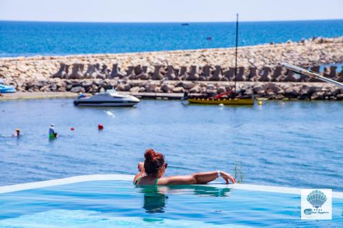 a woman sitting in a swimming pool in the water at Hotel Carmen Azzuro in Venus