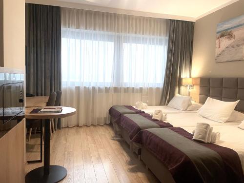 a hotel room with two beds and a table at Hotel CONRAD Comfort in Kraków