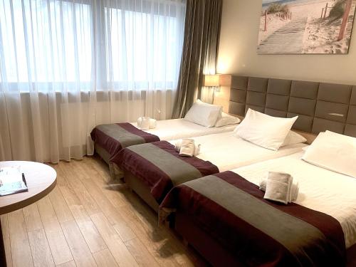a hotel room with two beds and a table at Hotel CONRAD Comfort in Kraków