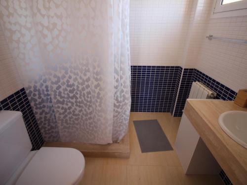 ein Badezimmer mit Toilette und Duschvorhang in der Unterkunft TRAMUNTANA - Casa amplia, moderna y muy bien equipada, situada en la zona de Grifeu - ES-228-144 in Llança