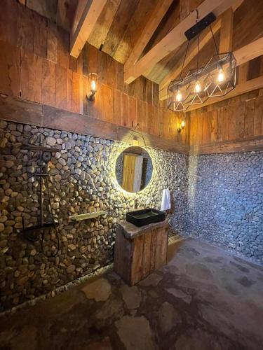 a stone bathroom with a sink and a mirror at The Adventurers Resort in Dhechiān di Bahlk