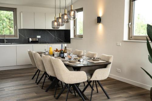 a dining room with a table and chairs in a kitchen at Kooparc vakantiepark in Giesbeek