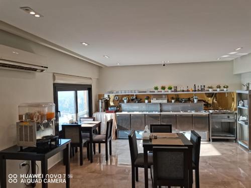 a restaurant with tables and chairs and a kitchen at The Nile Palace Hotel in Cairo