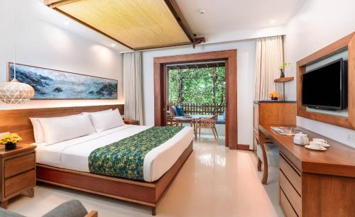 a hotel room with a bed and a television at Legian Beach Hotel in Legian