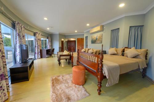a bedroom with a large bed and a living room at Villa 53 in Battaramulla