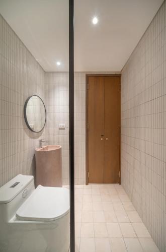 a bathroom with a toilet and a sink and a mirror at A Stay In Hanoi in Hanoi