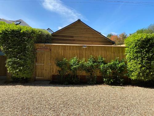 a wooden fence in front of a house at Le Petit Glen Uplyme brand new accommodation in Uplyme