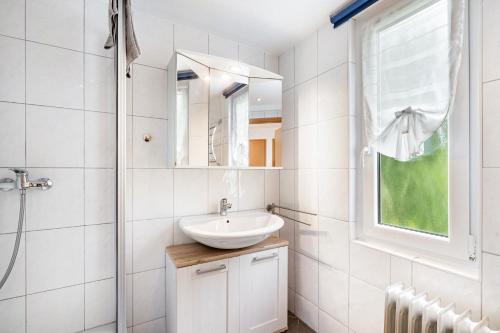 a white bathroom with a sink and a shower at Bungalow 71 in Stelzendorf