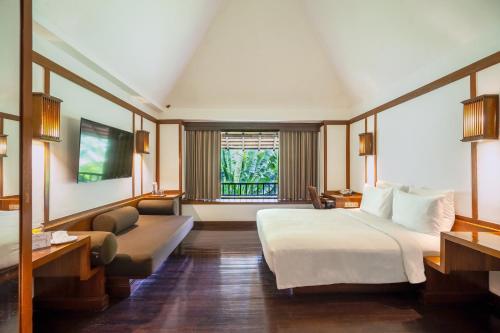 a hotel room with a bed and a window at Novotel Bogor Golf Resort in Bogor
