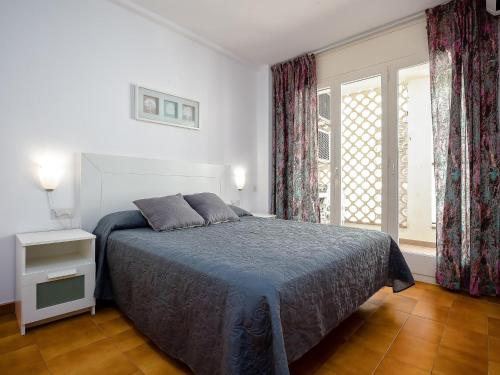 a bedroom with a bed and a large window at LLANÇÀ 8 LATERAL - Apartamento con vistas al mar, parking y Wifi. - ES-228-55 in Port de la Selva