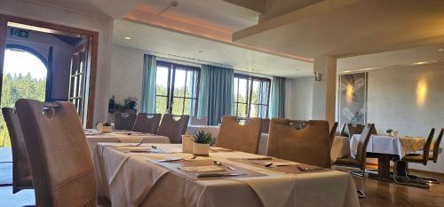 a dining room with tables and chairs and windows at Schwaben Resort Ebnisee in Ebni