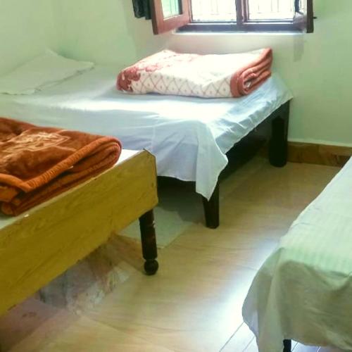 a room with two twin beds and a window at The Misty Hotel in Bhatwāri