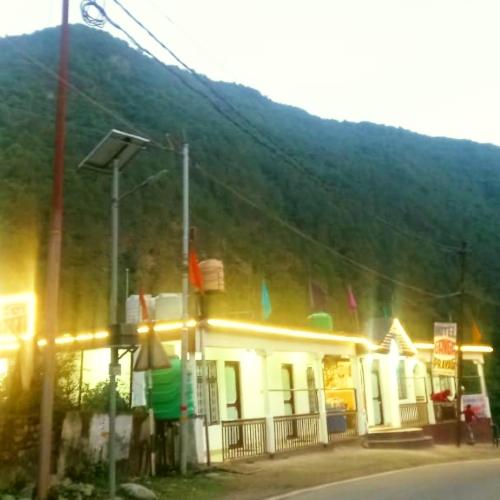 a building on the side of a street with a mountain at The Misty Hotel in Bhatwāri