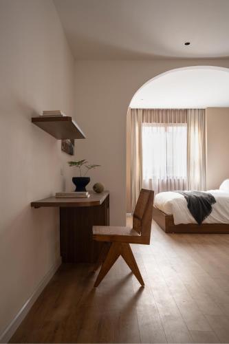 a bedroom with a bed and a chair and a window at A Stay In Hanoi in Hanoi