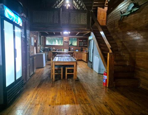 a kitchen with a wooden table in a cabin at Linga Bay Retreat in Morrumbene