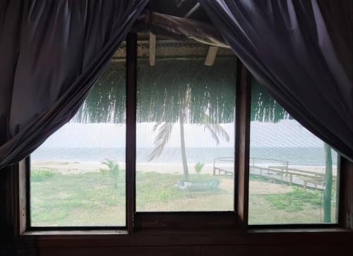 a window in a room with a view of the ocean at Linga Bay Retreat in Morrumbene