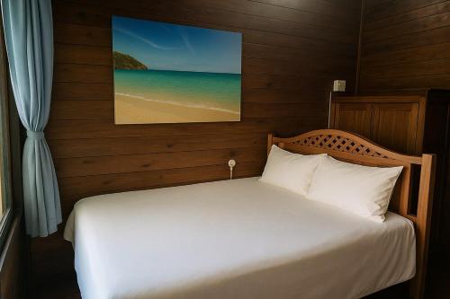 a bedroom with a bed with a picture of the beach at Linga Bay Retreat in Morrumbene