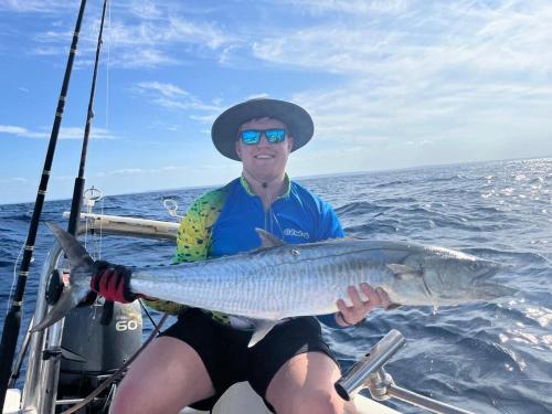a man on a boat holding a large fish at Linga Bay Retreat in Morrumbene