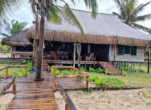 a house with a wooden deck in front of it at Linga Bay Retreat in Morrumbene