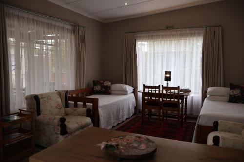 a living room with two beds and a table and chairs at Aalkie's Dream in Swellendam