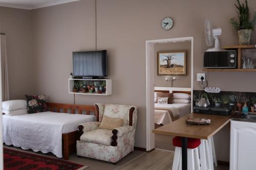 a bedroom with a bed and a chair and a table at Aalkie's Dream in Swellendam