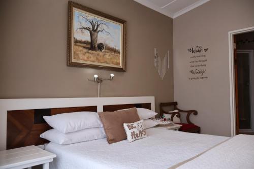 a bedroom with a bed and a picture on the wall at Aalkie's Dream in Swellendam