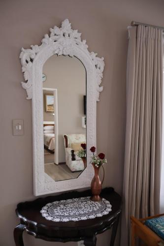 a mirror on a table in a room with a vase at Aalkie's Dream in Swellendam