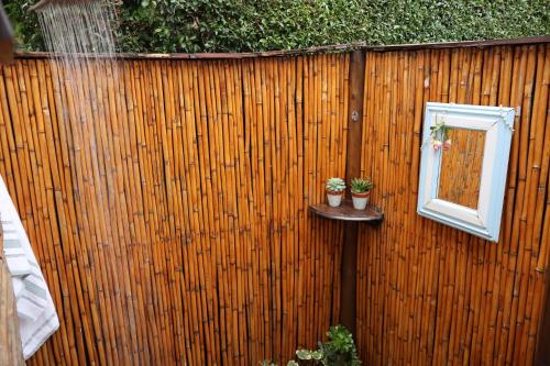 a fence with a window and two potted plants at Aalkie's Dream in Swellendam
