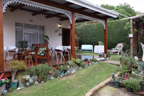 a patio with a table and chairs and plants at Aalkie's Dream in Swellendam