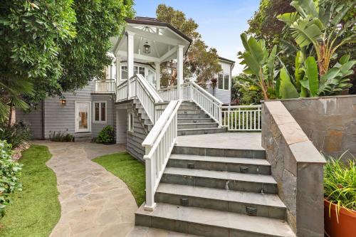 a white house with stairs in front of it at Malibu Dunes by Fieldtrip Expansive Hamptons-Style Estate w Private Beach Backyard in Malibu