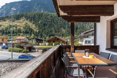 a table and chairs on a balcony with a view of a mountain at Apart Celina in Oetz