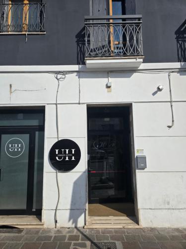 a white building with two doors and a balcony at Urban Hotel in Cesena
