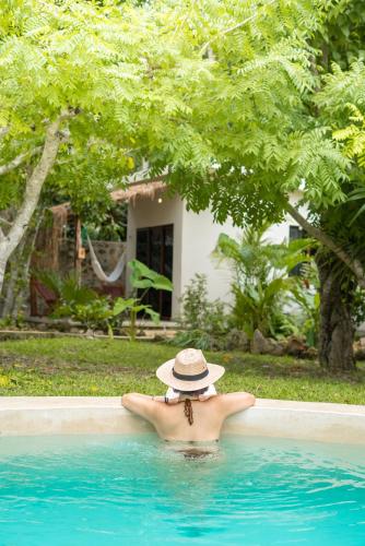 a man in a hat in a swimming pool at Casa Cactus Buenavista in Bacalar